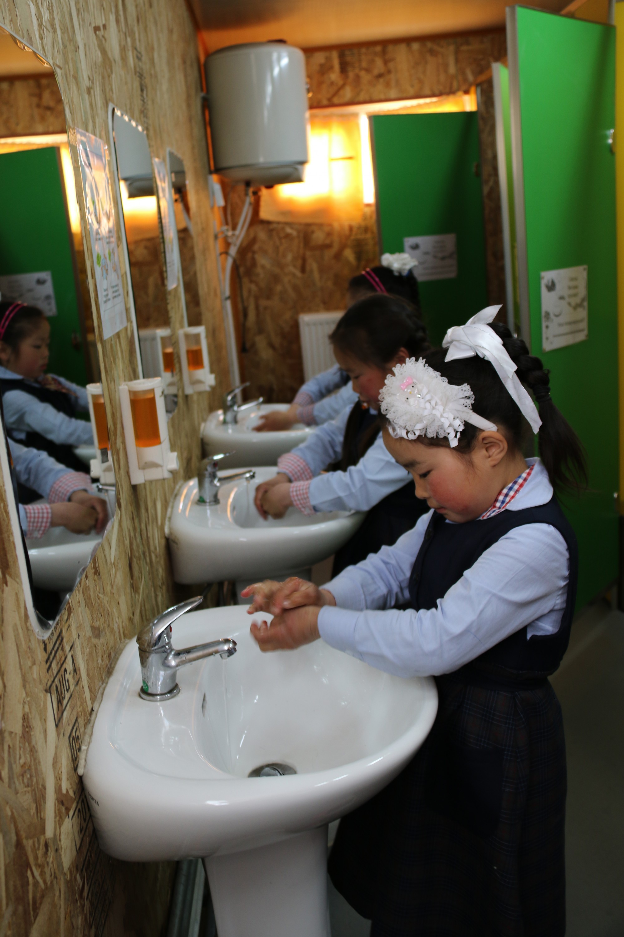 Хөвсгөл аймагт НҮБ-ын Хүүхдийн сангийн контейнер ашиглаж байгуулсан ариун цэврийн өрөөнд сурагчид гараа угааж байгаа нь